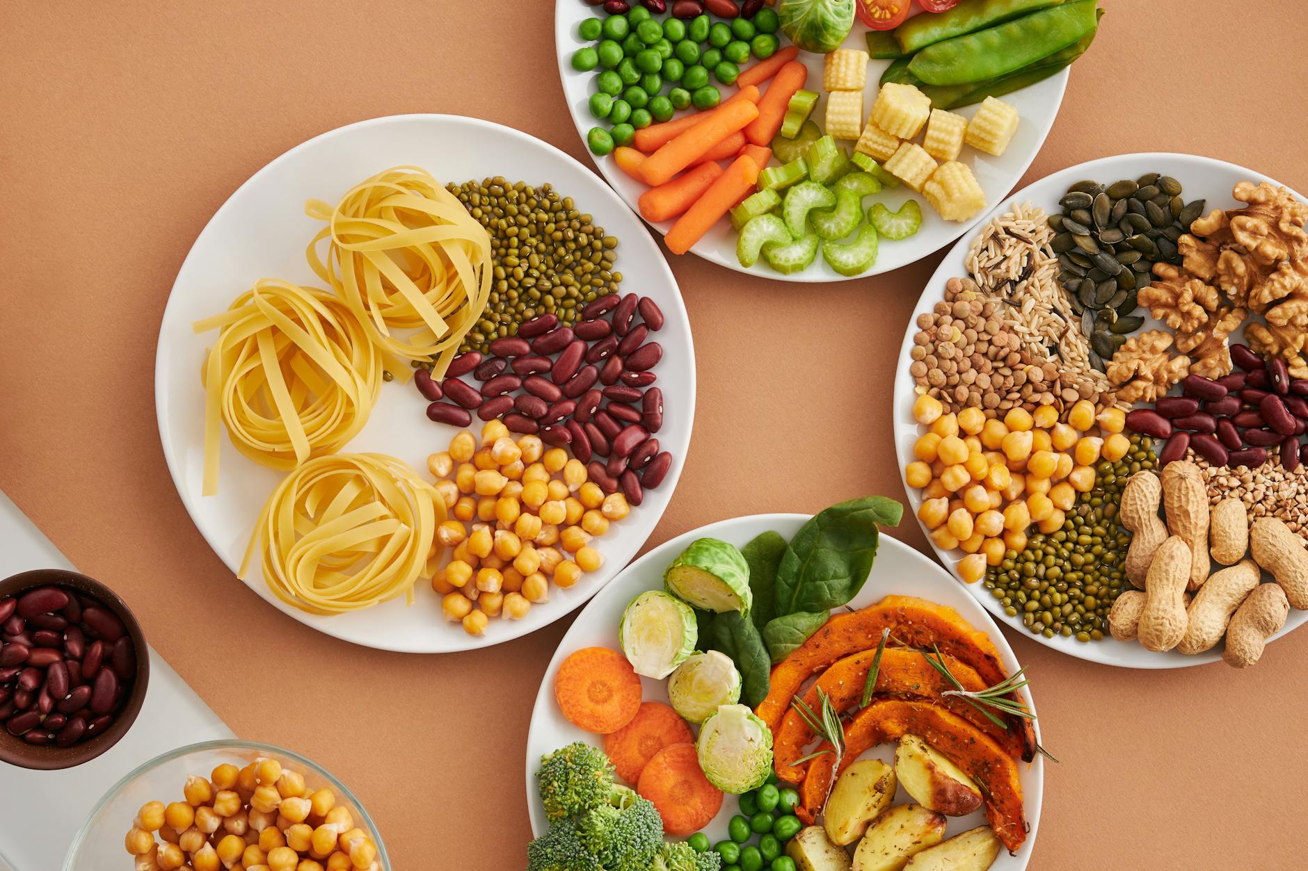 Assorted legumes, vegetables, nuts, and grains arranged on white plates
